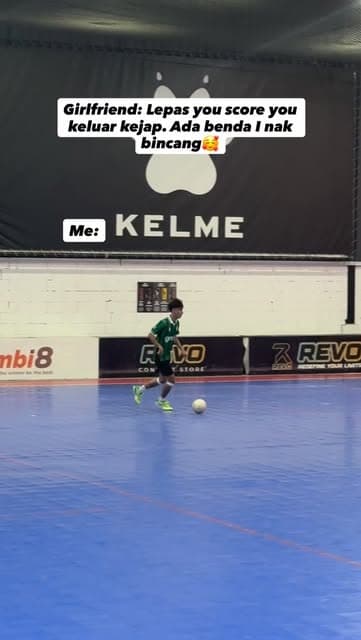 A PJJ player in the green home kit on the ball on a blue court